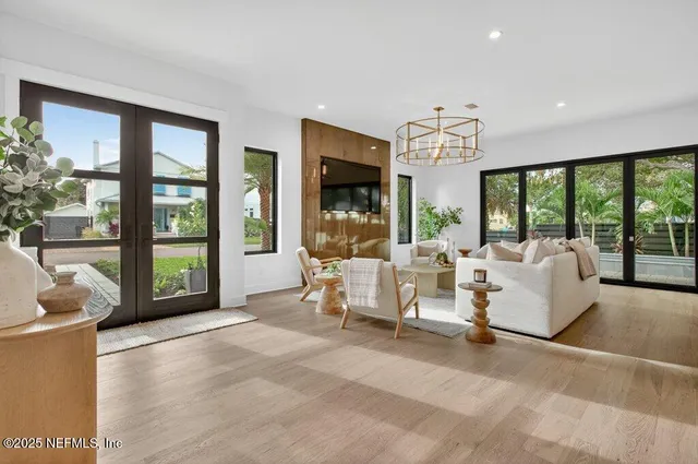 a living room with furniture a large window and a flat screen tv