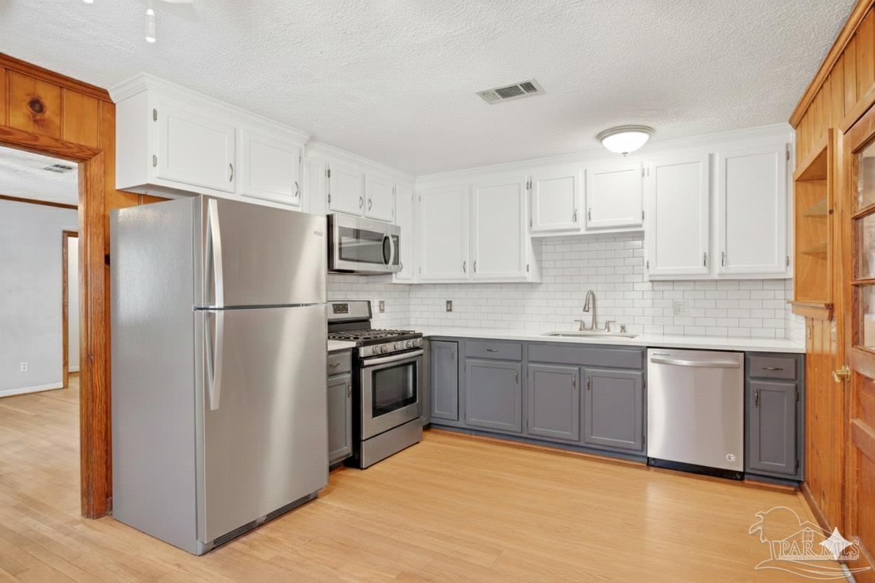 533 Ditmar Street Pensacola, FL 32503 - Photo 12 of 37 a kitchen with granite countertop a refrigerator stove top oven and sink
