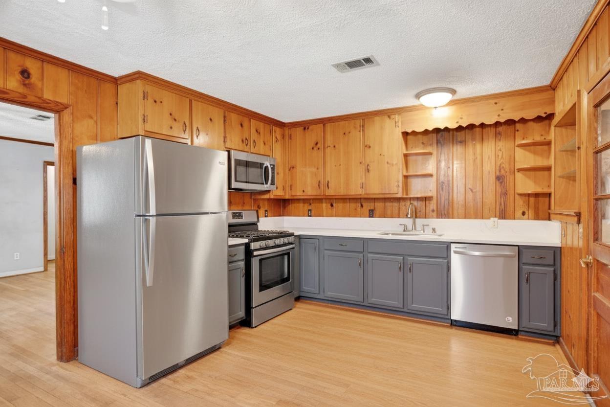 533 Ditmar Street Pensacola, FL 32503 - Photo 13 of 37 a kitchen with granite countertop stainless steel appliances a refrigerator a sink and cabinets
