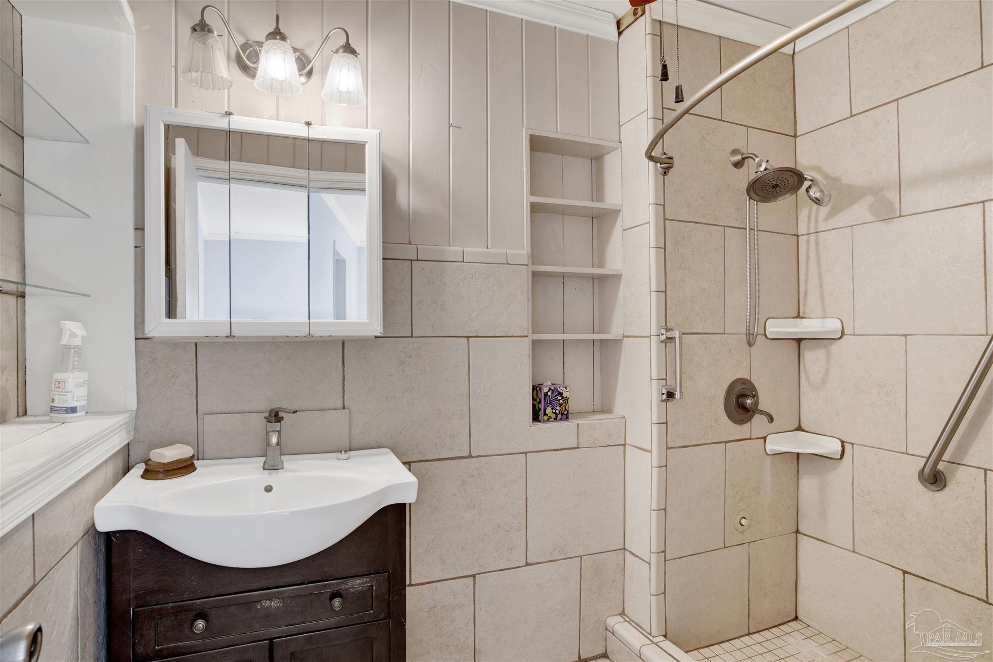 533 Ditmar Street Pensacola, FL 32503 - Photo 21 of 37 a bathroom with a sink a mirror and shower