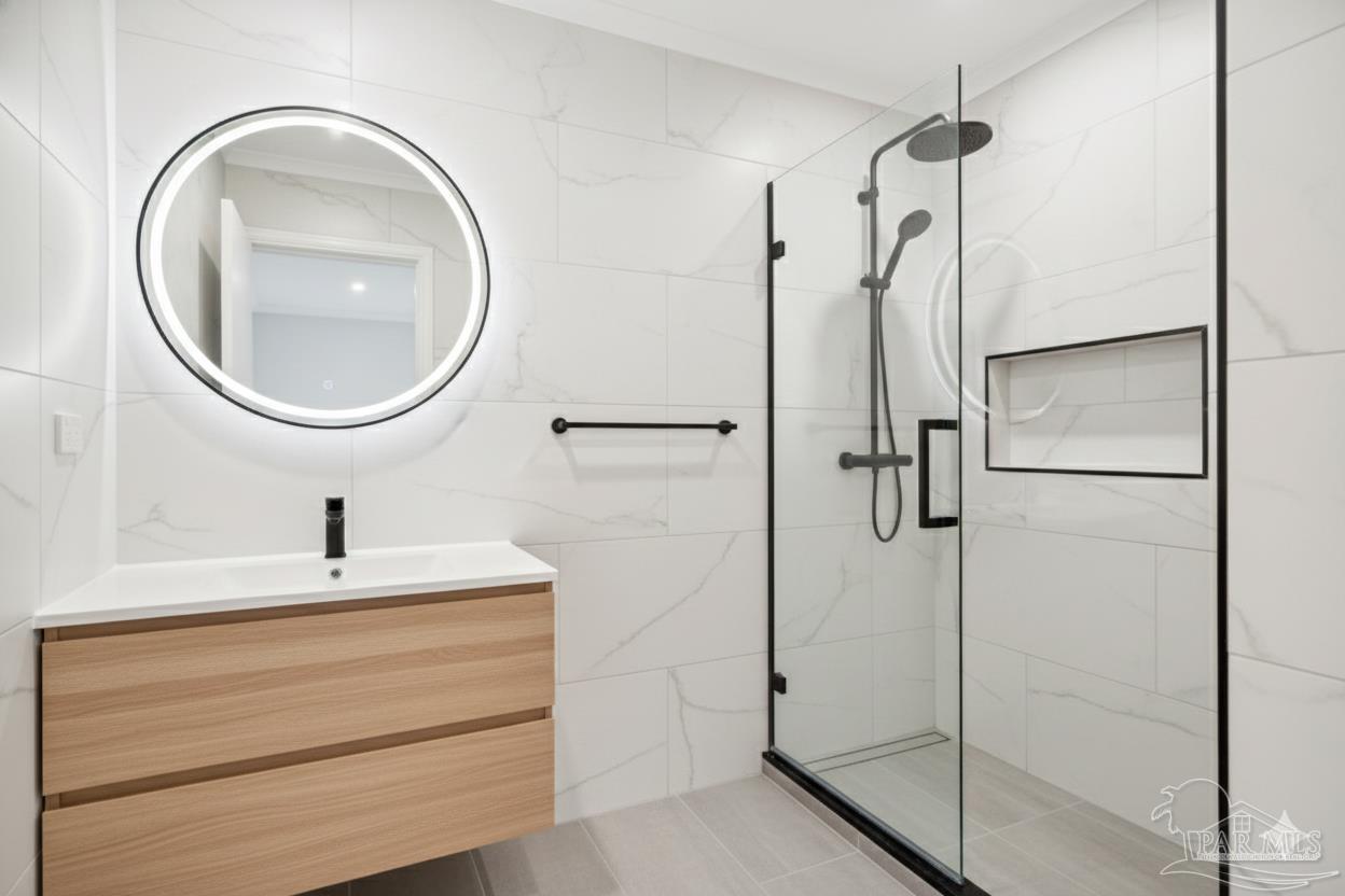 533 Ditmar Street Pensacola, FL 32503 - Photo 22 of 37 a bathroom with a sink a mirror and shower