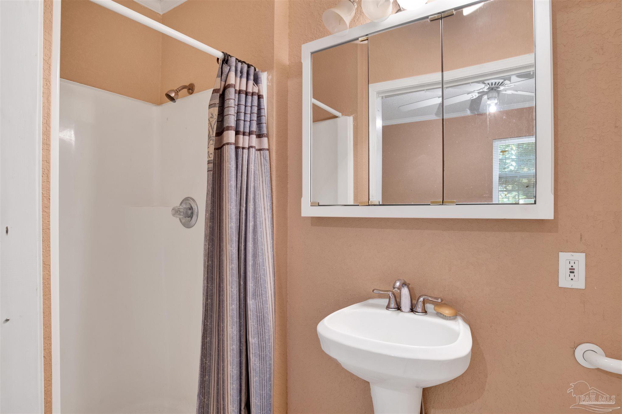 533 Ditmar Street Pensacola, FL 32503 - Photo 35 of 37 a bathroom with a sink a mirror a vanity and a shower