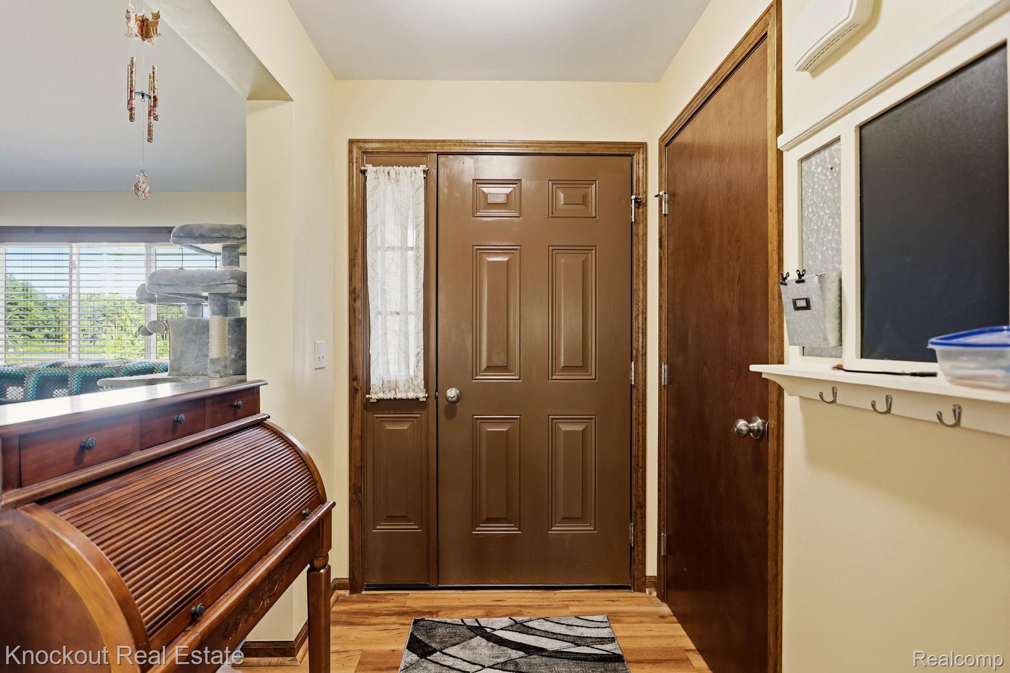 5727 Mackinaw Road Saginaw, MI 48604 - Photo 8 of 60 Entryway with wood-finish flooring, a paneled entry door, and a built-in wall shelf with coat hooks