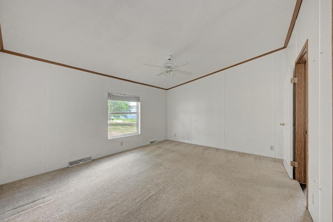 187 Horseshoe Bend Road San Marcos, TX 78666 - Photo 17 of 38 Unfurnished room featuring ornamental molding, light carpet, a decorative wall, and ceiling fan