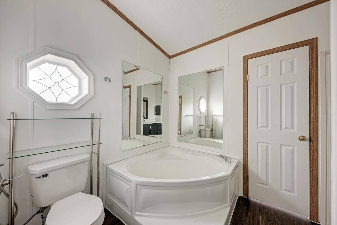 187 Horseshoe Bend Road San Marcos, TX 78666 - Photo 20 of 38 Bathroom featuring dark wood-style flooring, crown molding, and a bath