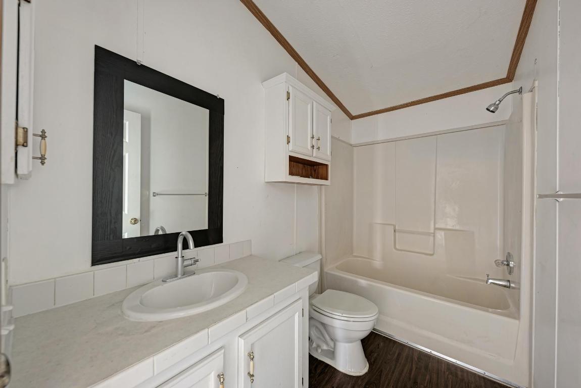 187 Horseshoe Bend Road San Marcos, TX 78666 - Photo 24 of 38 Full bath with shower / bath combination, vanity, ornamental molding, and dark wood-style floors