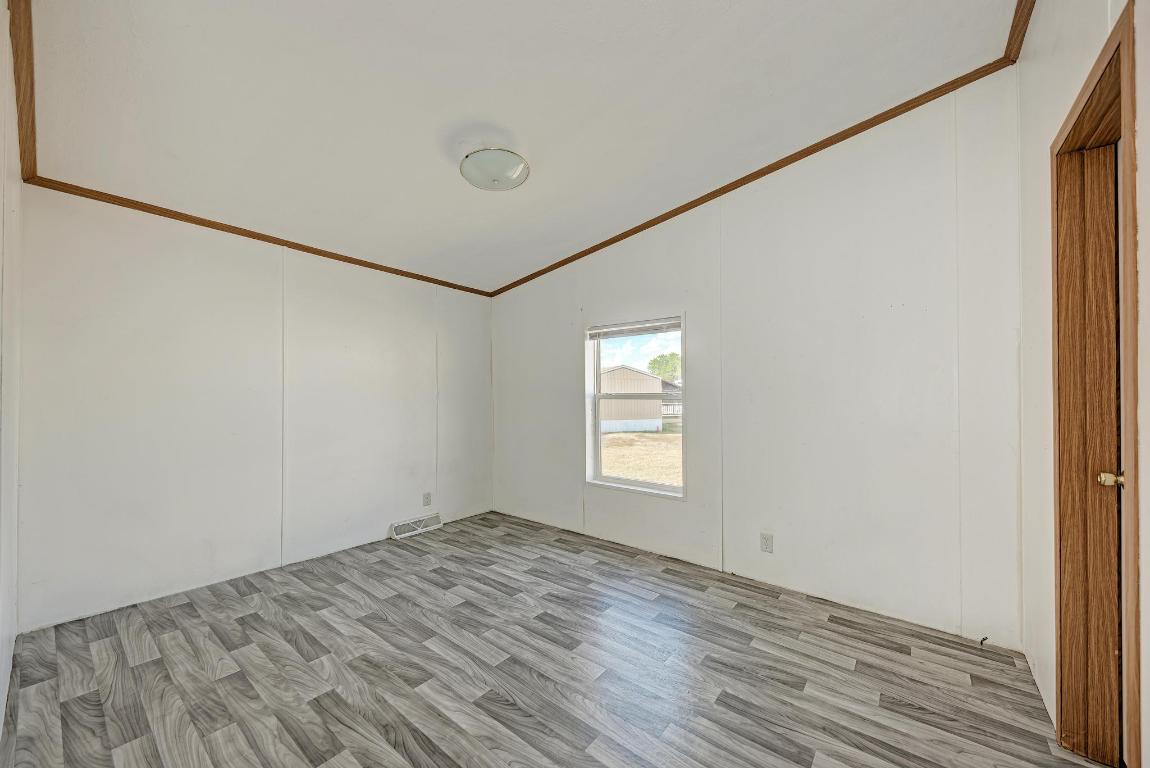 187 Horseshoe Bend Road San Marcos, TX 78666 - Photo 25 of 38 Unfurnished bedroom featuring crown molding, light wood finished floors, and lofted ceiling