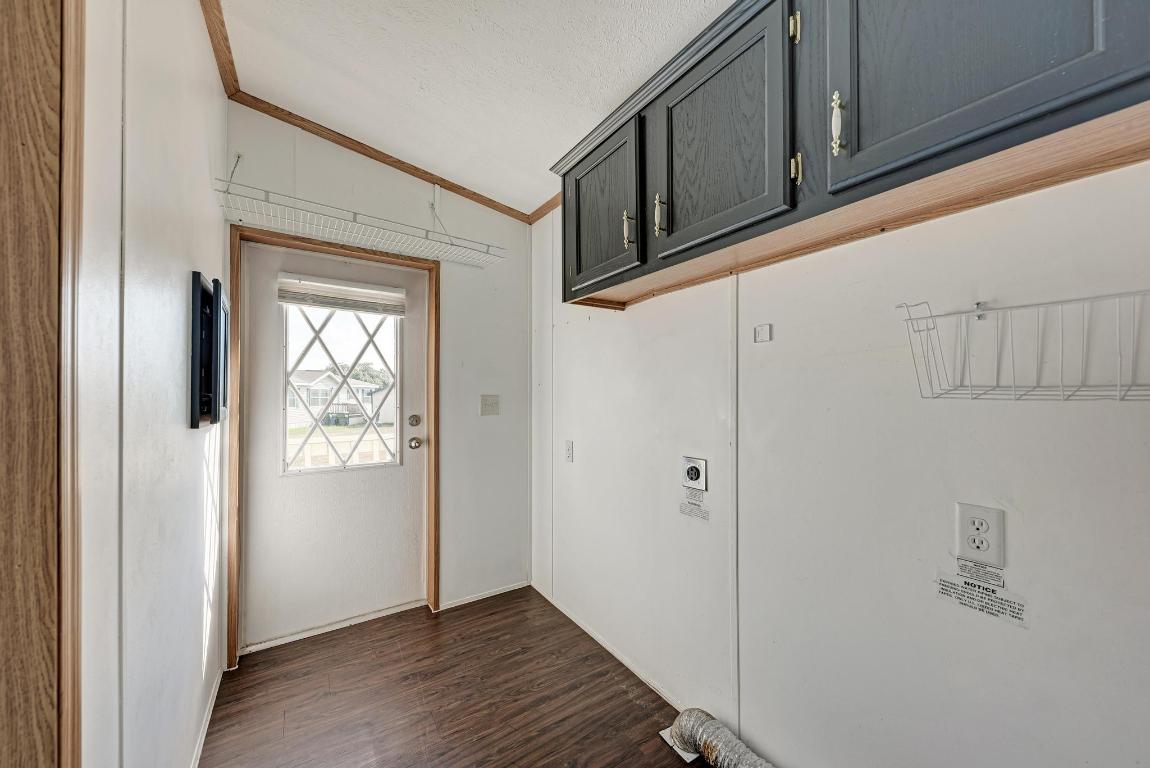 187 Horseshoe Bend Road San Marcos, TX 78666 - Photo 27 of 38 Laundry area with crown molding, dark wood-type flooring, cabinet space, and hookup for an electric dryer