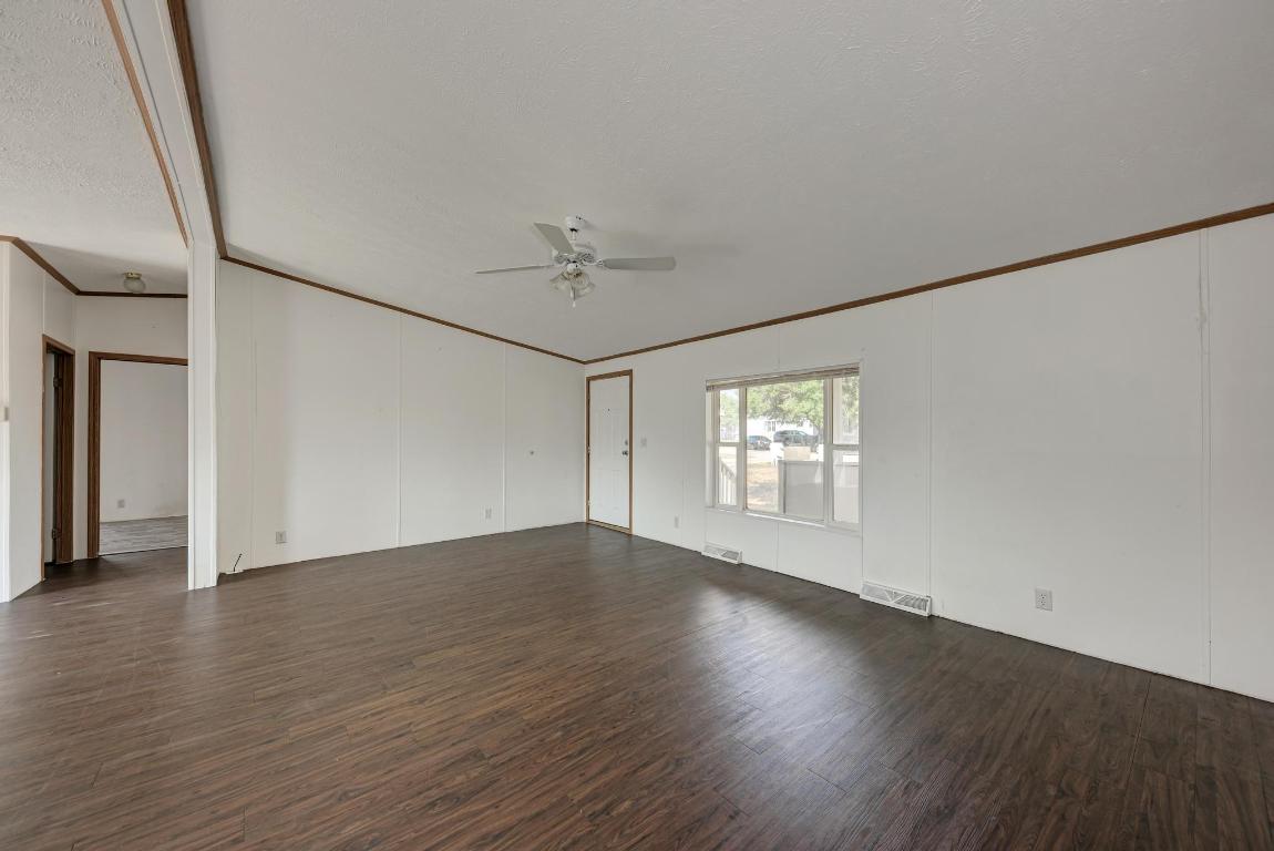 187 Horseshoe Bend Road San Marcos, TX 78666 - Photo 8 of 38 Spare room featuring crown molding, dark wood-type flooring, a ceiling fan, and a textured ceiling
