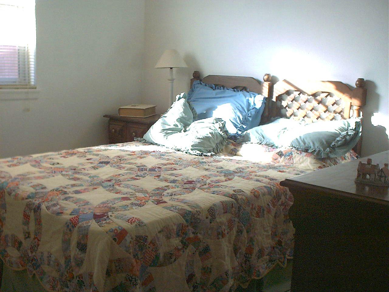 5211 South Travis Street Amarillo, TX 79110 - Photo 8 of 10 a bed with white sheets and pillows on it