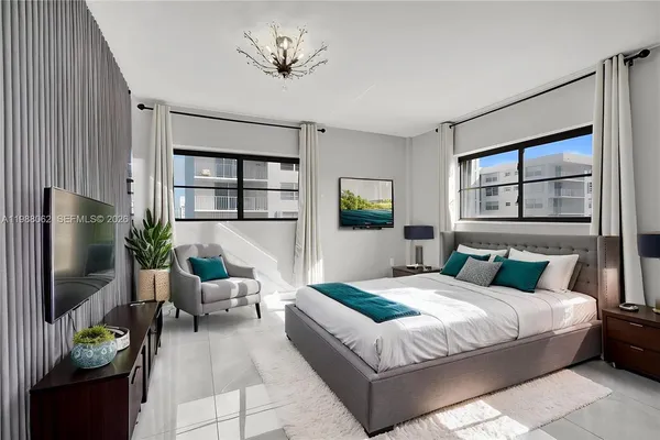 a bedroom with a large bed and a chandelier