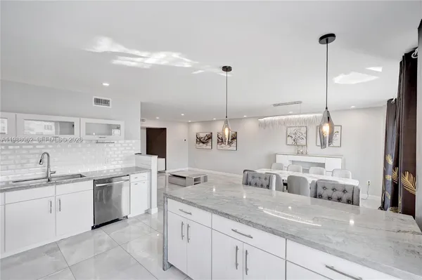 a kitchen with kitchen island a sink stainless steel appliances and cabinets