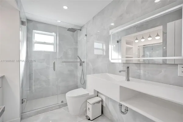 a bathroom with a sink toilet vanity and shower