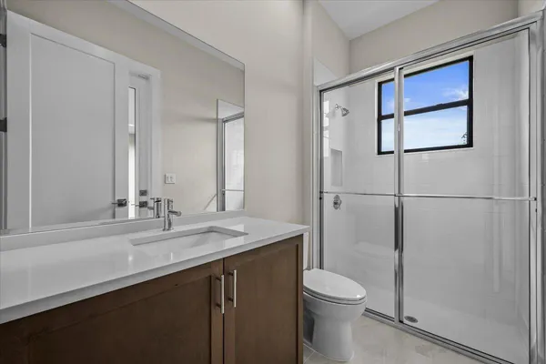 a bathroom with a sink a toilet and shower