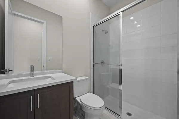 a bathroom with a sink a toilet a shower and a mirror