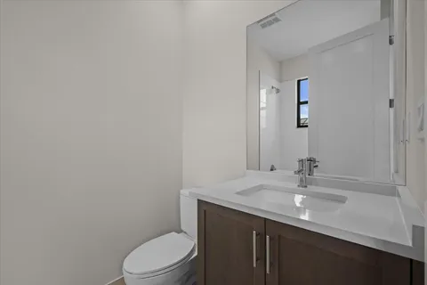 a bathroom with a sink a toilet and mirror