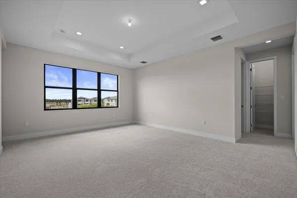 an empty room with windows and ceiling fan