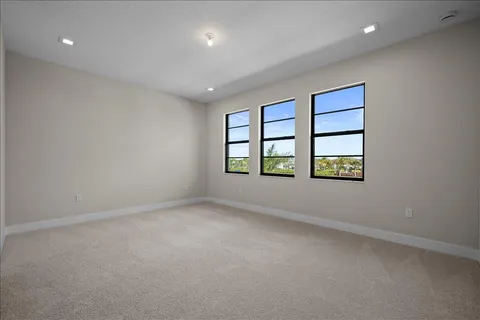 an empty room with windows and ceiling fan