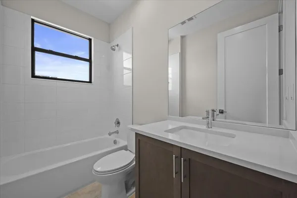 a bathroom with a granite countertop toilet a sink and a bathtub