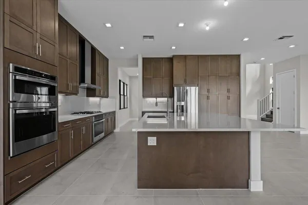 a large kitchen with stainless steel appliances and a large counter top