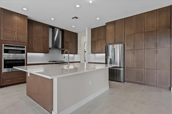 a kitchen with stainless steel appliances a refrigerator sink and microwave
