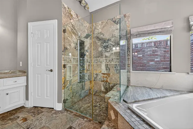 a bathroom with a granite countertop shower and a sink