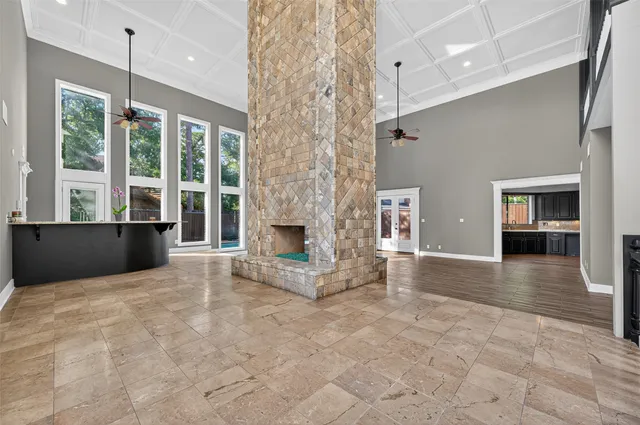 a view of an empty room with a fireplace and a chandelier