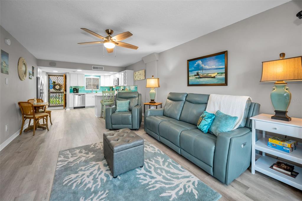 203 Tarpon Point, Unit 203 Tarpon Springs, FL 34689 - Photo 11 of 39 a living room with furniture and a flat screen tv with wooden floor