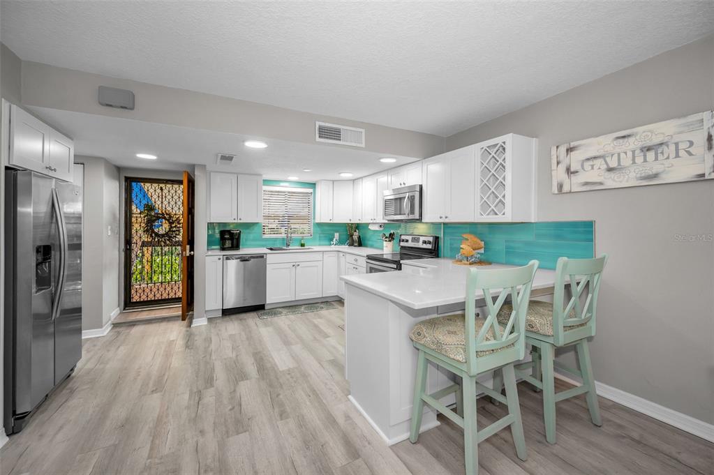 203 Tarpon Point, Unit 203 Tarpon Springs, FL 34689 - Photo 12 of 39 a kitchen with stainless steel appliances kitchen island granite countertop a refrigerator and a stove top oven