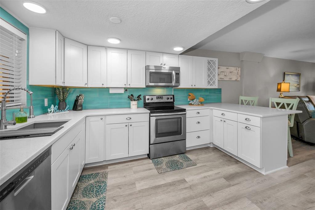 203 Tarpon Point, Unit 203 Tarpon Springs, FL 34689 - Photo 16 of 39 a kitchen with white cabinets sink and stainless steel appliances