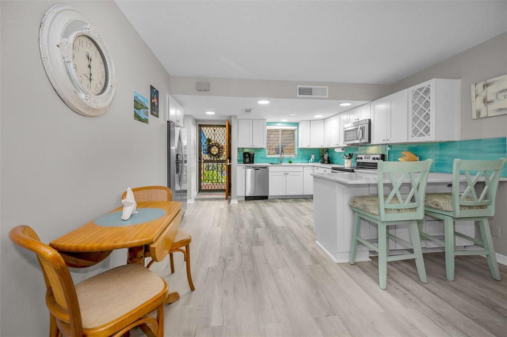 203 Tarpon Point, Unit 203 Tarpon Springs, FL 34689 - Photo 19 of 39 a kitchen with a dining table chairs and a view of kitchen