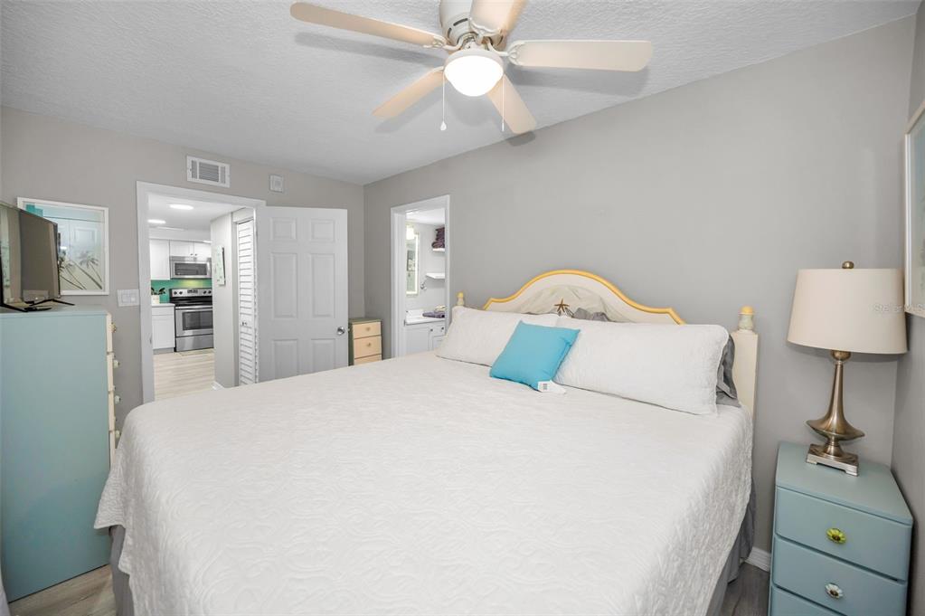 203 Tarpon Point, Unit 203 Tarpon Springs, FL 34689 - Photo 20 of 39 a bedroom with a bed and a chandelier