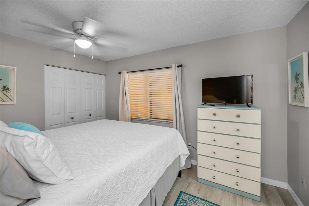 203 Tarpon Point, Unit 203 Tarpon Springs, FL 34689 - Photo 22 of 39 a bedroom with a bed and a flat tv screen on dresser