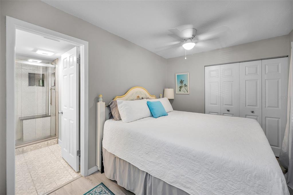 203 Tarpon Point, Unit 203 Tarpon Springs, FL 34689 - Photo 23 of 39 a bedroom with a large bed and a chandelier