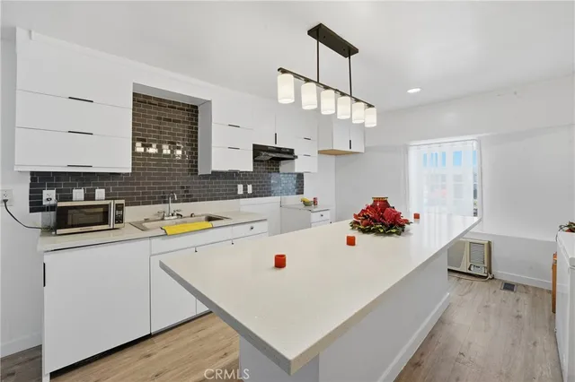 a kitchen with a sink a stove and chairs