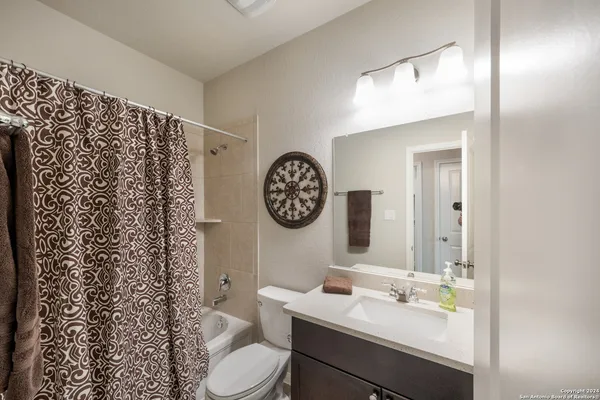 a bathroom with a toilet sink vanity and mirror