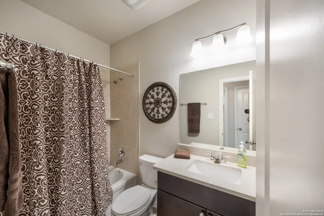 a bathroom with a toilet sink vanity and mirror
