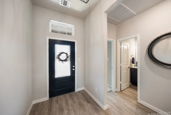 a view of a hallway to rooms and wooden floor