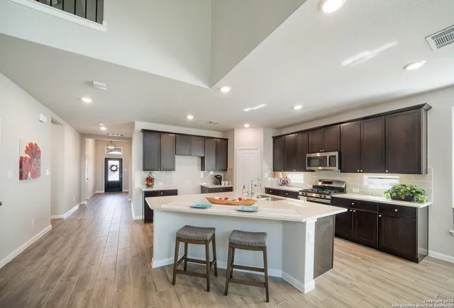 a kitchen with stainless steel appliances kitchen island granite countertop a stove a sink a refrigerator and a oven