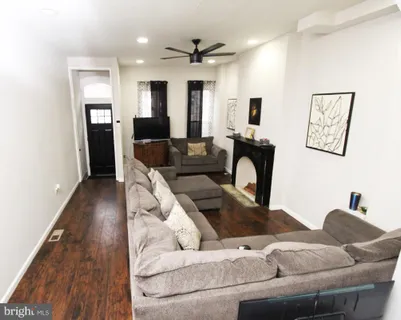 a living room with furniture and wooden floor