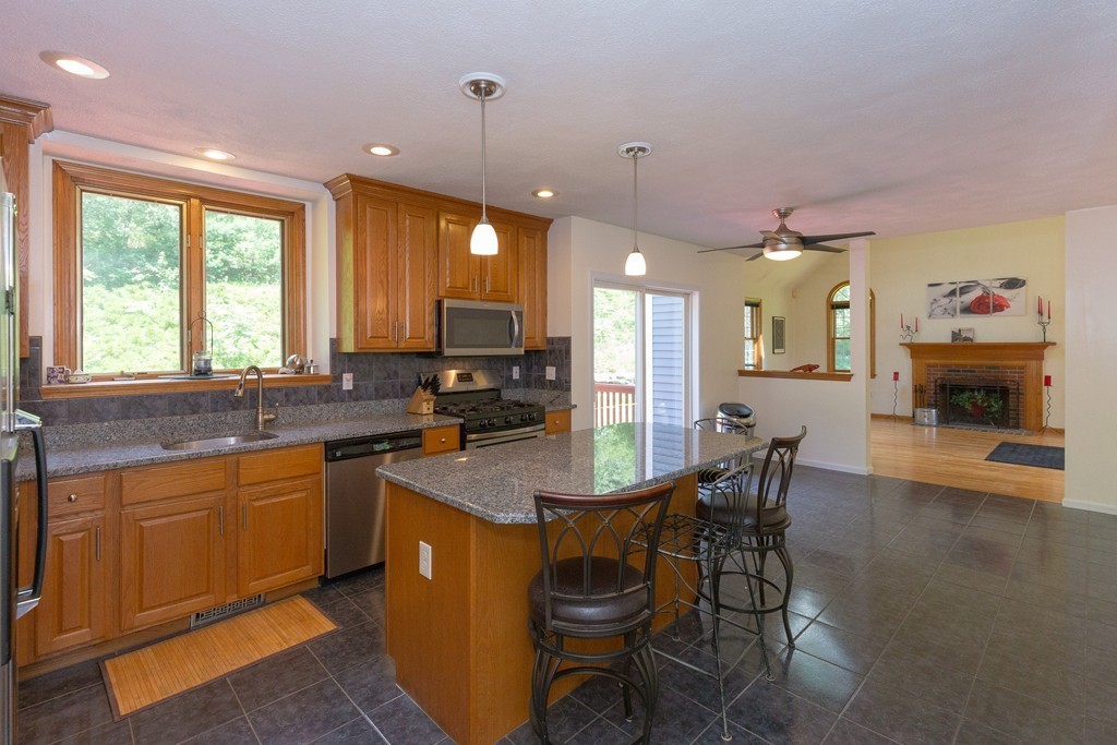 88 Providence Road Westford, MA 01886 - Photo 11 of 29 a kitchen with granite countertop a sink a stove a dining table and chairs