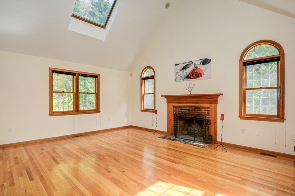 88 Providence Road Westford, MA 01886 - Photo 5 of 29 an empty room with windows fireplace and fans