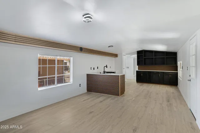 a view of a kitchen with wooden cabinet and a large window