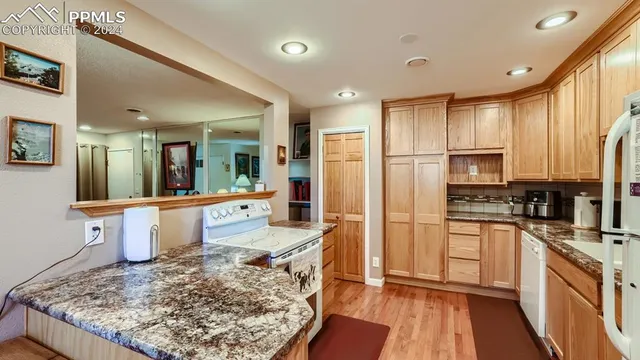a large kitchen with stainless steel appliances granite countertop a lot of counter space and a sink