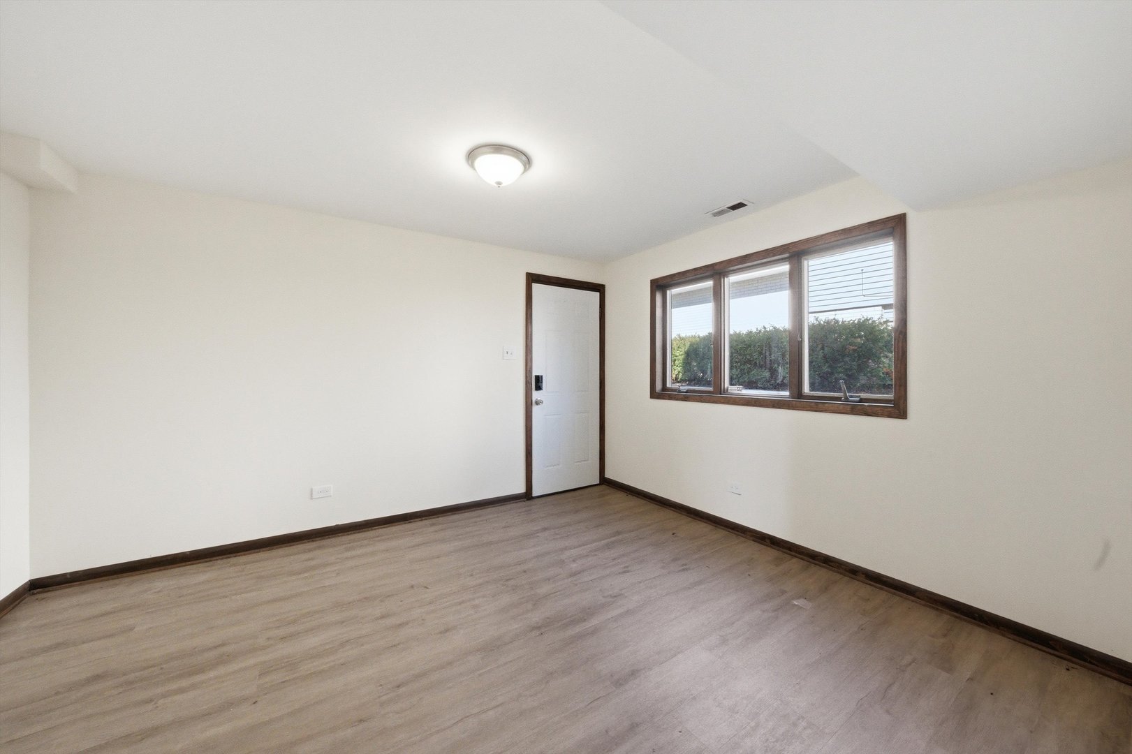 831 Violet Lane Matteson, IL 60443 - Photo 10 of 21 an empty room with wooden floor and windows