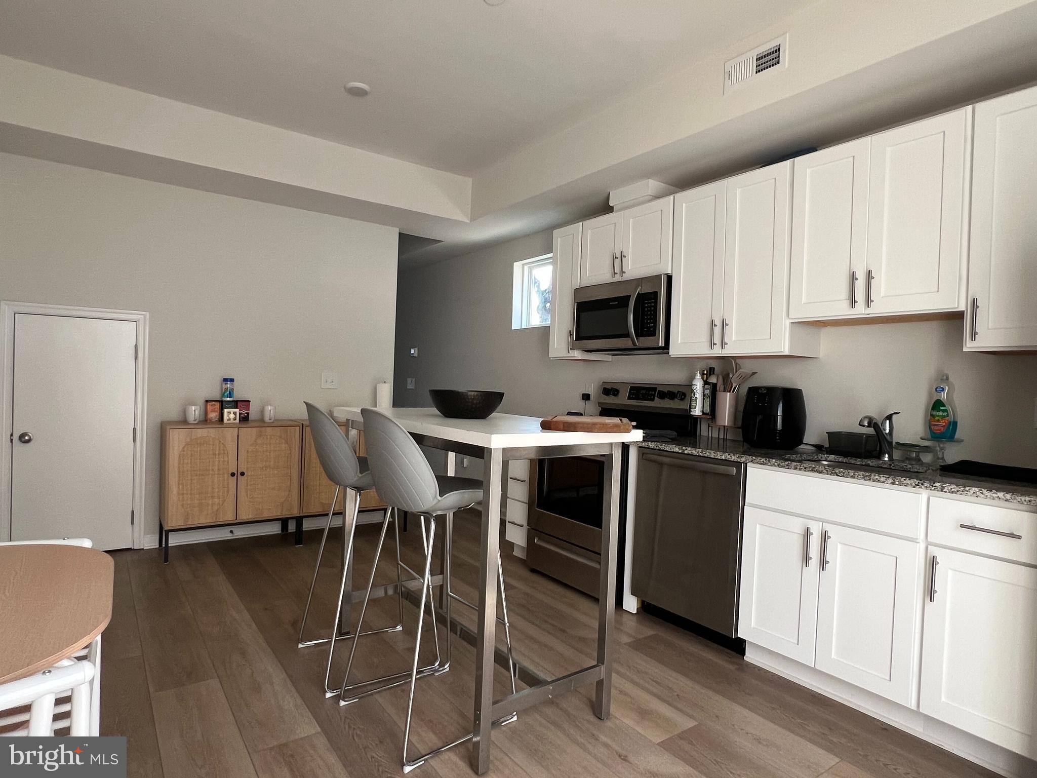 2700 Sears Street Philadelphia, PA 19146 - Photo 5 of 10 a kitchen with stainless steel appliances a stove a sink a microwave a refrigerator and cabinets