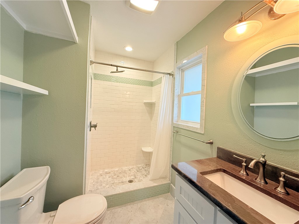 126 Marie Place Portland, TX 78374 - Photo 33 of 40 a bathroom with a granite countertop sink toilet and shower