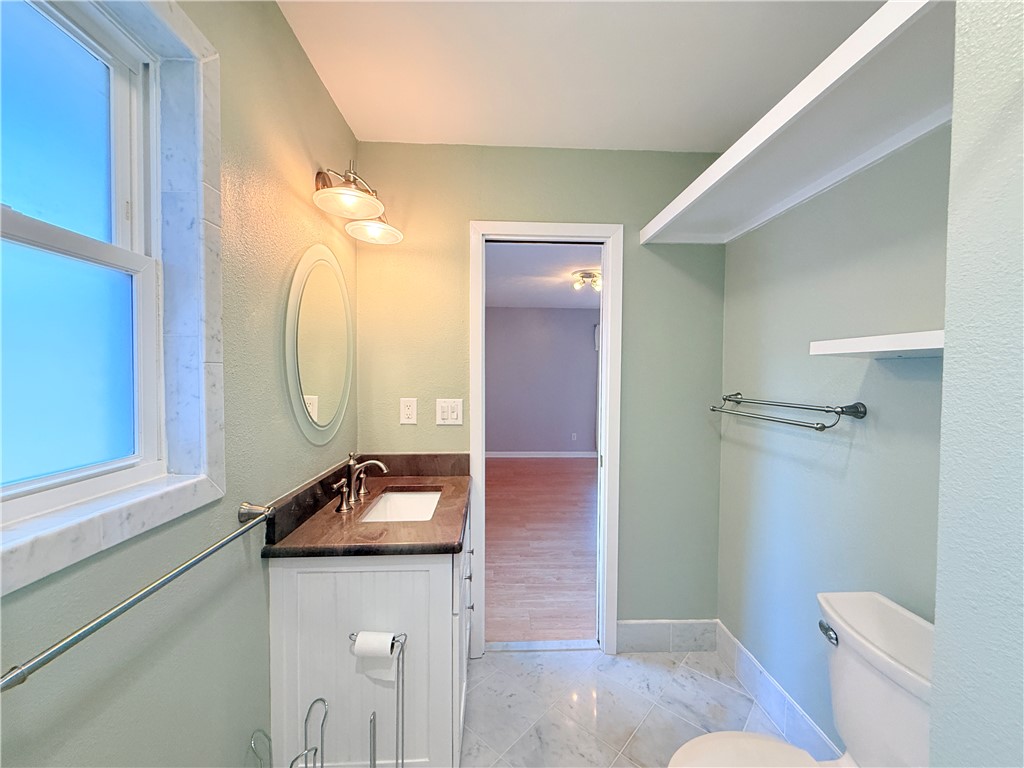 126 Marie Place Portland, TX 78374 - Photo 34 of 40 a bathroom with a sink a toilet a mirror and vanity