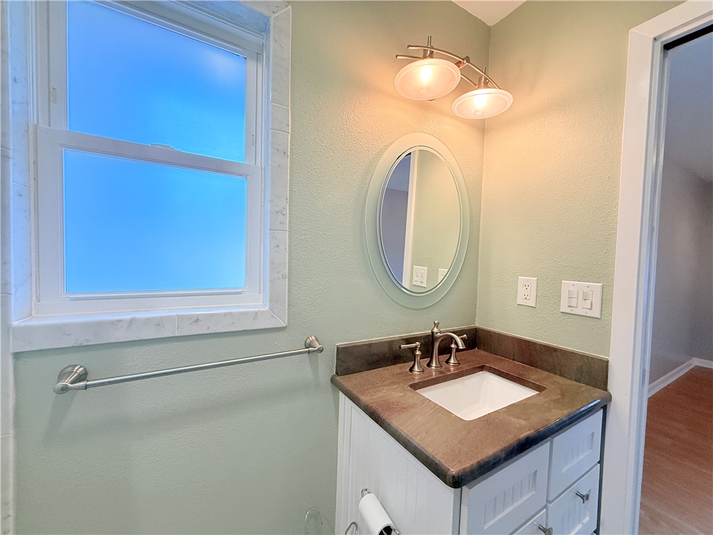 126 Marie Place Portland, TX 78374 - Photo 35 of 40 a bathroom with a granite countertop sink a mirror and a shower