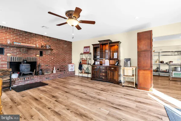 a kitchen with stainless steel appliances a refrigerator a stove a sink dishwasher and white cabinets with wooden floor